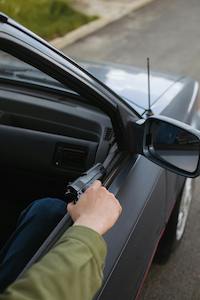 Person showing a gun through their car's window